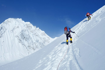 Fototapeta na wymiar Climber reaches the summit of mountain peak enjoying the landscape view