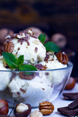 close up Vanillaice cream with mint, nuts and chocolate on dark background. Ice cream decoration. Vegetarian food. Summer, sweet food. Food background.