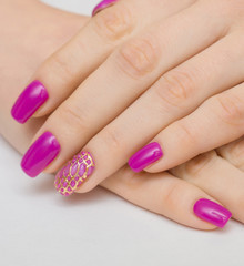 Manicure withpink nail Polish on women's hand.