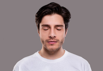 Fototapeta premium Portrait of handsome millennial man with closed eyes