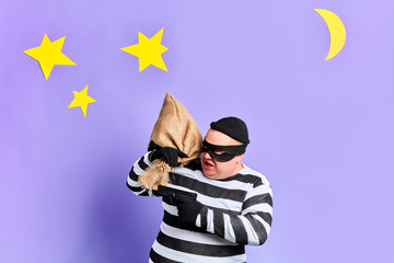 angry cruel thief being afraid of punishmnet. close up portrait. isolated blue background. studio...