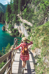Fototapeta na wymiar woman walking by hiking trail around braies lake in italy dolomites mountains. activity leisure lifestyle