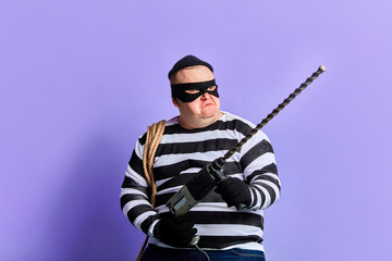serious robber with a drilling machine makes illegal work. plump thief steals a drilling...