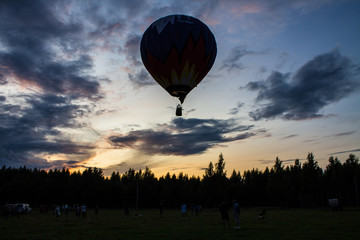 flying balloon with passengers in a basket against the blue sky at the festival of Aeronautics in Pereslavl-Zalessky Russia summer evening