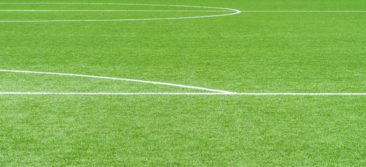Green artificial grass soccer sports field with white stripe lines