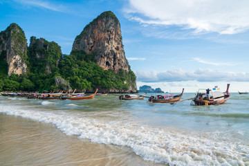 Beautiful tropical railay beach with Thai traditional wooden longtail boat at Krabi, Thailand