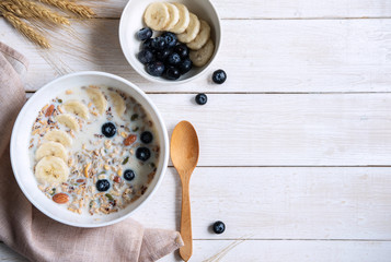 Bowl of granola almond and grains with blueberry and banana on wooden table, Healthy breakfast