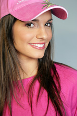 Jeune femme brune avec une casquette rose