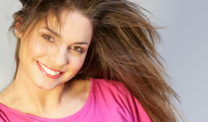 Fototapeta premium Jeune femme brune souriante avec un top rose