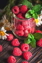 Raspberries in a Cup on a dark background. Summer and healthy food concept. Background with copy space. Selective focus.