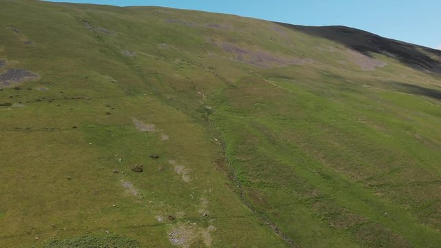 An ascending aerial shot of a stunning country hillside. The footage shows lush green English countryside. Taken at Barbon Beck, Carnforth in June to capture the best of the nature in the area.