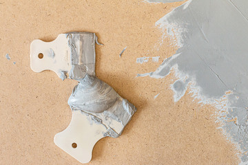 Renovating equipment isolated on wooden background. Putty-knife pattern