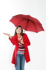 Jeune femme brune souriante sous un parapluie rouge