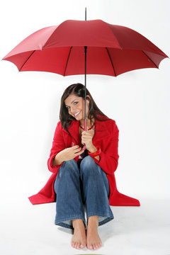 Jeune femme brune souriante sous un parapluie rouge