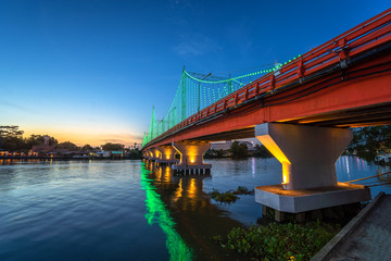 The city lights of Surat Thani at twilight with the Bridge and reflection over the Tapee River in Surat Thani , Thailand