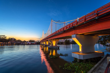 The city lights of Surat Thani at twilight with the Bridge and reflection over the Tapee River in Surat Thani , Thailand