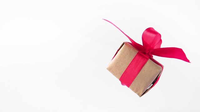 Gift box with red ribbon spinning on white screen. 360 degree rotation. seamless loop. zero gravity. levitation. chroma key. copyspace. Concept sales, discount price, christmas holidays and shopping.
