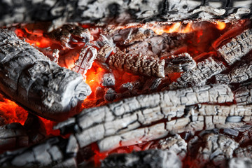 bright red-orange coals of heat from a burnt tree close up, background.