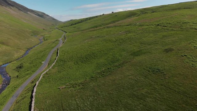 An ascending shot of Barbon Beck, Carnforth, Lancashire, England. This stunning countryside features a stream running alongside a small country lane.