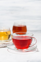 assortment of tea in glass cups on white background, vertical closeup