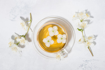 Obraz na płótnie Canvas cup of fresh fragrant green tea with jasmine, top view