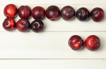 Ripe plums on a wooden background close-up. Open space, healthy food concept, plants, soil, organic natural products, natural food, vegetarian dishes, vegetables, raw, food festival