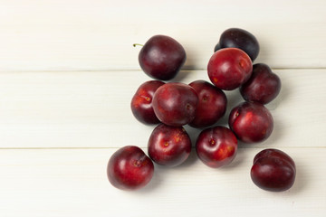 Ripe plums on a wooden background close-up. Open space, healthy food concept, plants, soil, organic natural products, natural food, vegetarian dishes, vegetables, raw, food festival