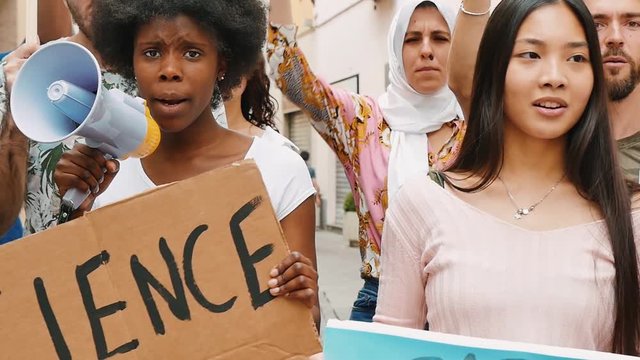Public demonstration on the street against global warming and pollution. Group of multiethnic people making protest about climate change and plastic problems in the oceans