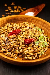 Roasted and salted sunflower seeds. Sunflower seeds in the bowl over the wooden background. Vegan food.