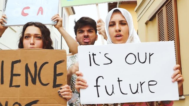 Public demonstration on the street against global warming and pollution. Group of multiethnic people making protest about climate change and plastic problems in the oceans