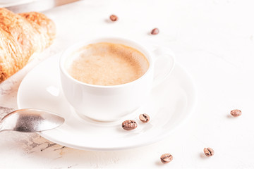 Traditional breakfast with fresh croissants on white background.