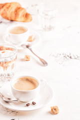 Traditional breakfast with fresh croissants on white background.