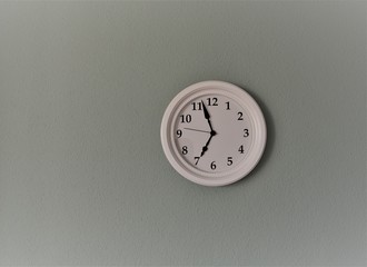 weiße Uhr mit grüner Wand