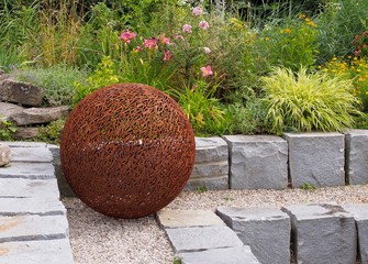 Gartendesign - befestigte Blumenwiese mit Metallkugel