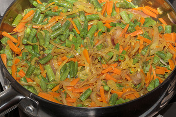 Fried colorful vegetables in a steel pan. Concept of a vegan food.