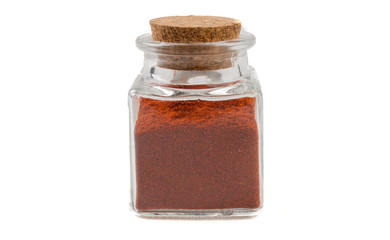 milled or ground paprika or red pepper in glass  jar on isolated on white background. front view. spices and food ingredients.