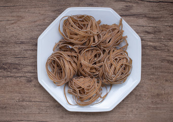 spaghetti pasta on the white plate on a wooden background