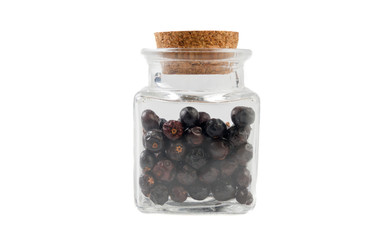 juniper berries in glass  jar on isolated on white background. front view. spices and food ingredients.
