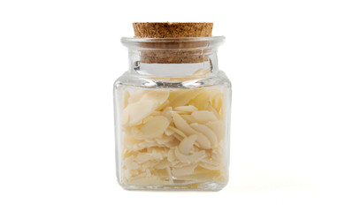 almond flakes in glass  jar on isolated on white background. front view. spices and food ingredients.
