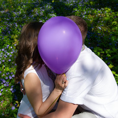 Portrait of a Couples Lovers Kissing Hiding Behind the Balloon.
