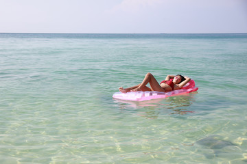 Young pretty woman line down sun bathing on  float swimming seat