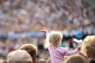 young girl waving estonian flag at the folk song festival in Pirita, Tallinn