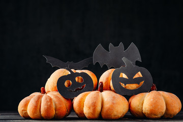 homemade cakes in shape of pumpkin and halloween decorations on a dark background. Cooking for...
