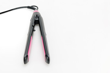 Hair iron on white mat background with copy space