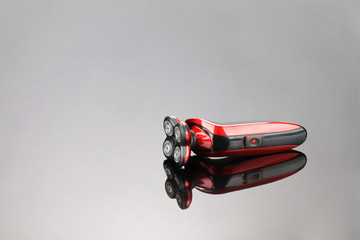 Electrical red shaver, haircut isolated on the grey mirror background with copy space