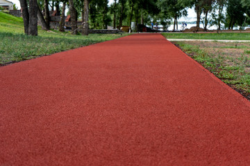 Resilient rubber coating for sports fields, jogging and cycling paths
