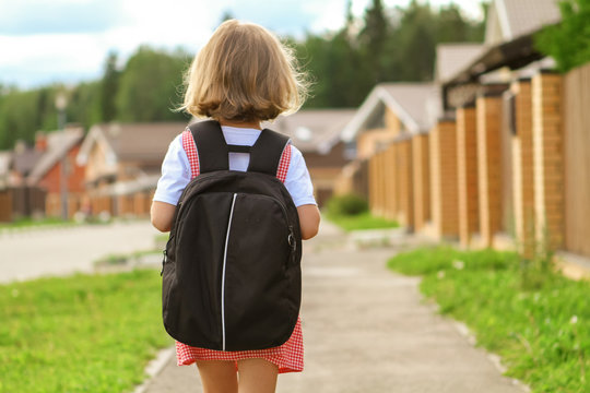 Back To School. Cute Little Blonde Child Girl With Backpack Running And Going To School From Home