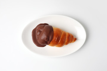 お皿にのせた チョココルネ 菓子パン 白背景