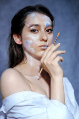 Obraz premium Creative fashion beauty portrait of a beautiful young woman with an artistic tassel in her hands.