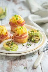 roasted potato with  bacon, cheeze, squash on white plate on wooden background